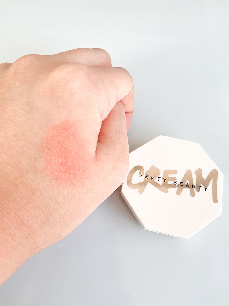 Visão do Blush Fenty Cream na mão mostrando a cor e a consistência do produto